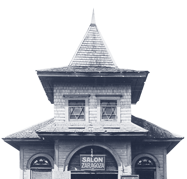 A vintage building with a steep roof and a sign reading “Salon Zaragoza” above the entrance.