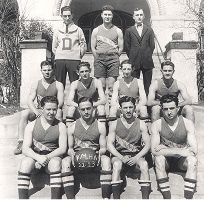 Black and white photo of a vintage basketball team posing on steps, holding a ball labeled “YMHA 32-33.”.