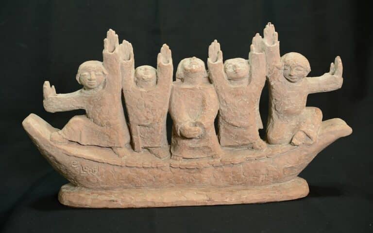 Clay sculpture of five joyful figures in a boat, all with arms raised, against a black background.