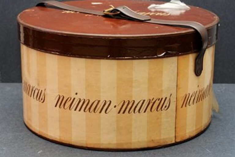 Round vintage Neiman Marcus hat box with a brown lid, beige striped sides, and leather handle.
