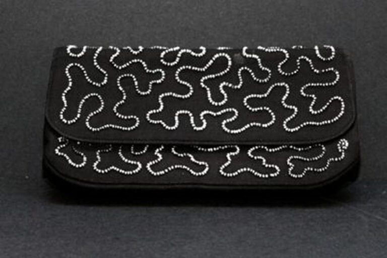 A black clutch purse with a wavy, silver beaded pattern on the front, set against a dark background.