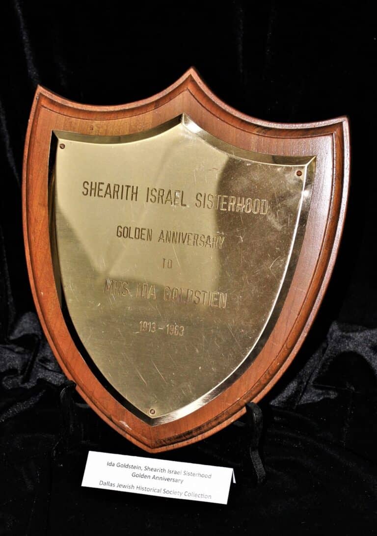 A gold shield-shaped plaque honoring Mrs. Ida Goldstein for Shearith Israel Sisterhood’s golden anniversary, 1913–1963.