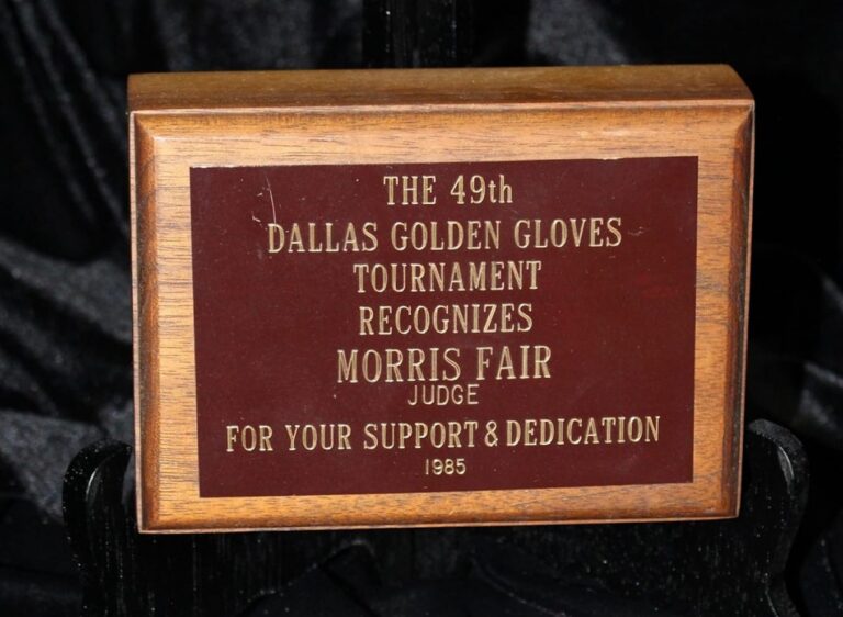 Wooden plaque honoring Morris Fair, judge, for support and dedication at the 49th Dallas Golden Gloves Tournament, 1985.