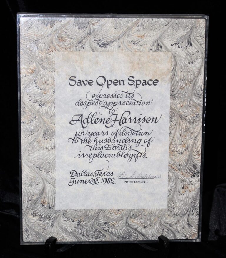 A plaque reading “Save Open Space” honors Addene Harrison for conservation work, dated Dallas, Texas, June 22, 1982.