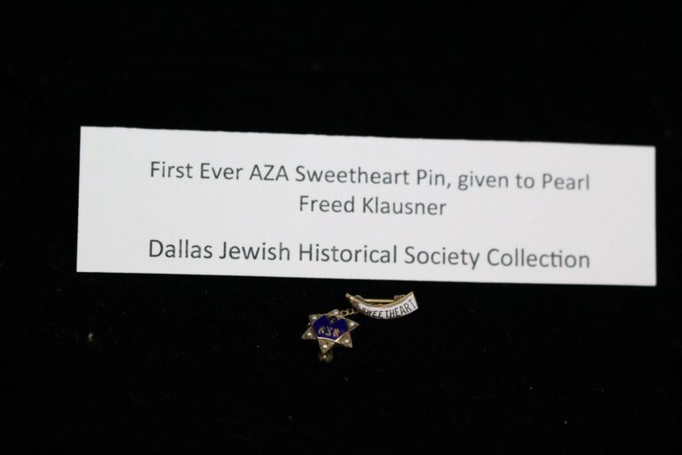 Small pin labeled “Sweetheart” with a star, displayed with a card noting its historical significance and recipient.