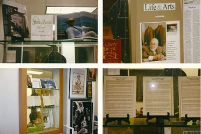 Four display cases feature magazines, photos, articles, and posters on shelves in a library or exhibit setting.