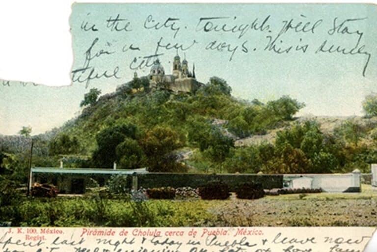Old postcard of the Cholula pyramid in Mexico with handwritten text overlaying the top of the image.