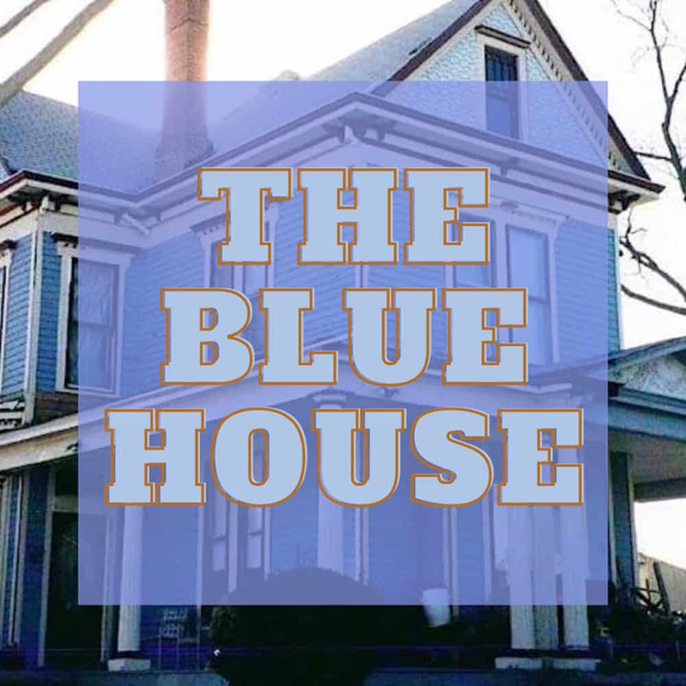 A blue Victorian-style house with “THE BLUE HOUSE” written in bold letters over a blue square overlay.